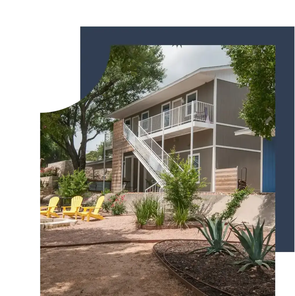 A property with yellow lawn chairs and several plants out front.